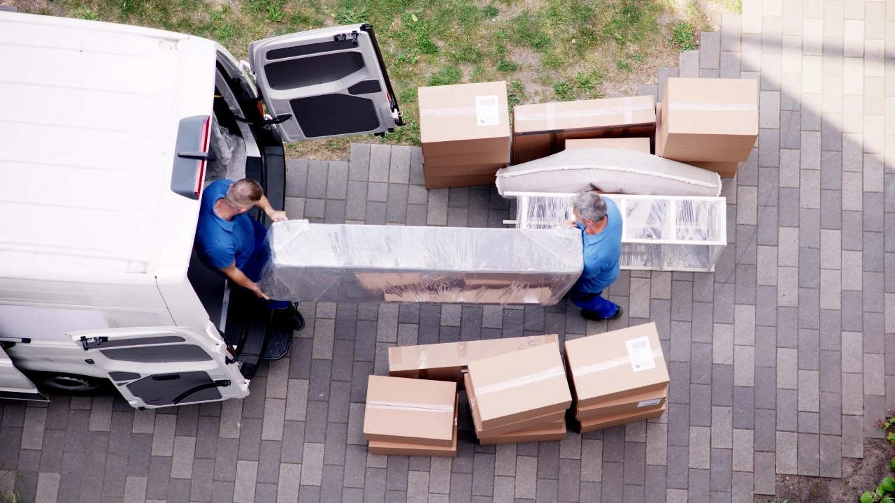 Umzugshelfer laden Möbel und Umzugskartons in einen Transport-LKW vor einem Wohnhaus – Umzugsunternehmen Cloppenburg im Einsatz.