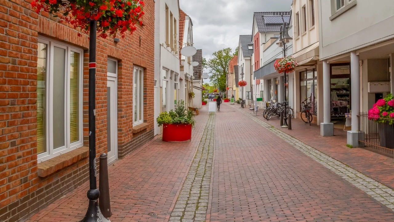Altstadtgasse in Jever mit roten Backsteinhäusern, Pflastersteinen und Blumendekoration – stimmungsvoll und einladend.
